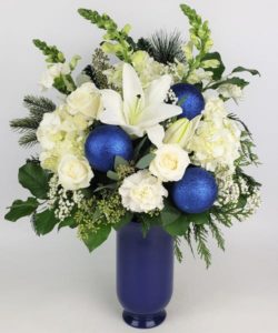 Take their breath away with this stunning arrangement. Featuring glimmering accents and delicate textures alongside rich blues and elegant whites, it calls to mind the beauty of our own Cascade Mountains in their most majestic season.