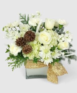 A beautiful mix of roses, lilies, and hydrangea with delicate filler flowers, designed in a cube vase.