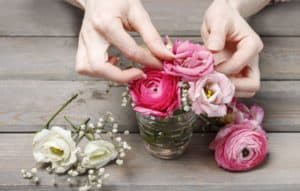 Woman making floral wedding decorations. Tiny bouquet of beautiful pink flowers