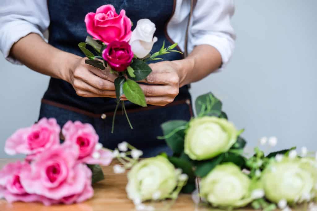 Arranging artificial flowers vest decoration at home, Young woman florist work making organizing diy artificial flower, craft and hand made concept.