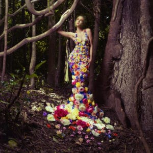 Blooming gorgeous lady in a dress of flowers in the rainforest