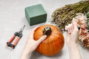 How to make a Thanksgiving centerpiece: bouquet of flowers in pumpkin.