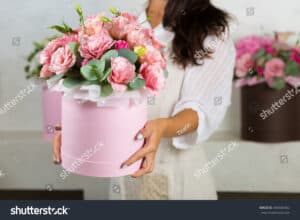 Woman carrying pink flower arrangement