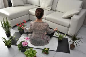 Woman meditating surrounded by plants