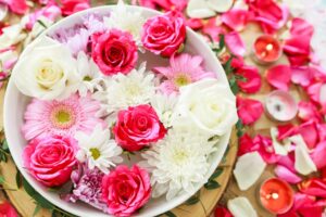 Colorful blossoms in bowl with petals