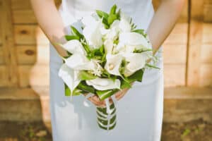 Bride holding bouquet of calla lilies