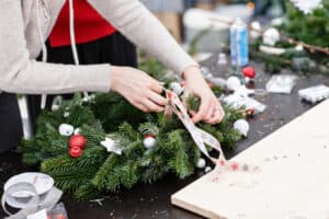 Adding ribbons to holiday wreath