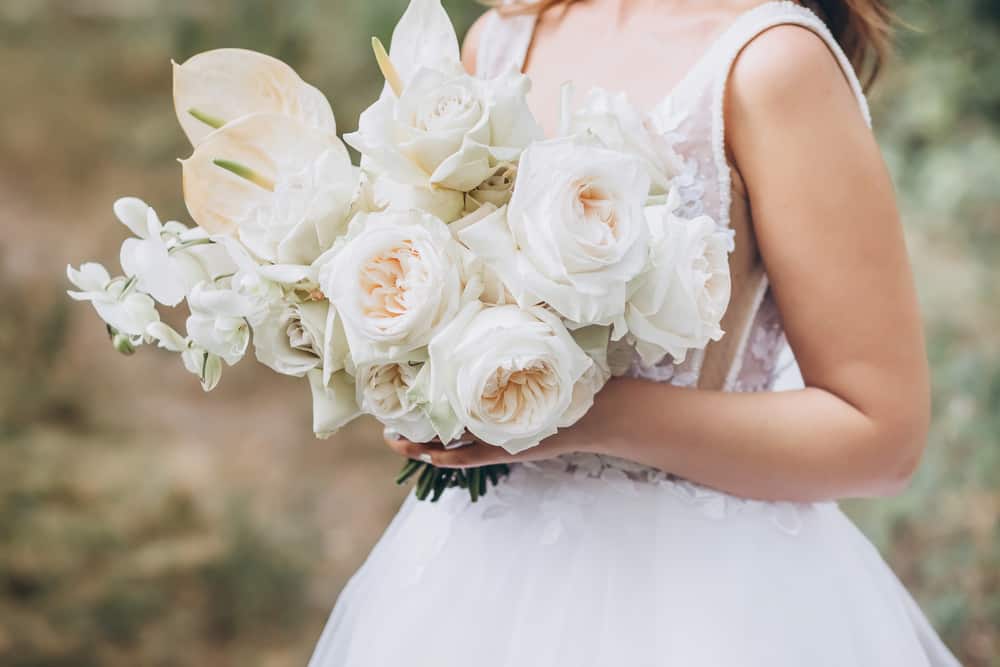 Bride holding all-white flower bouquet