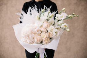 Person holding monochromatic white flower bouquet