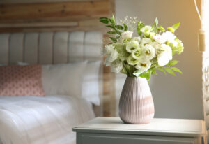 White flowers on a vase on a nightstand