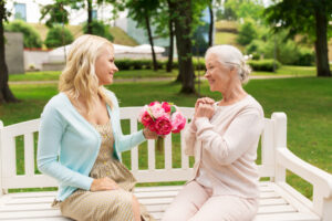 Young woman giving older women flowers