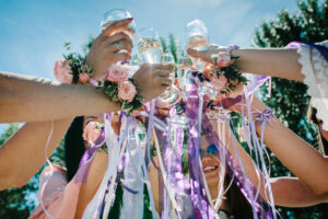 Women wearing corsages with ribbons toasting with glasses