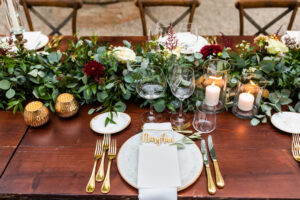 Table runner with greener and red blooms