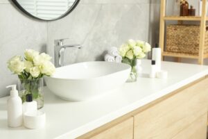 Vases of white roses in bathroom