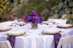 Purple floral centerpiece n table with lavender tablecloth