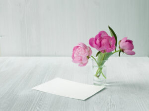 Peonies in water with card