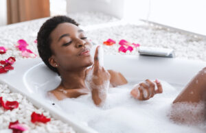 Woman in bath with bubbles and petals