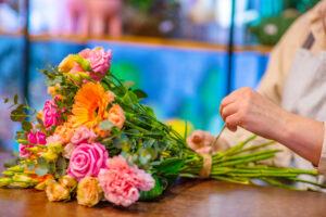 Woman tying twine around bouquet of flowers