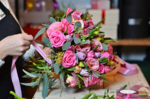 Florist building hand-tied bouquet of flowers