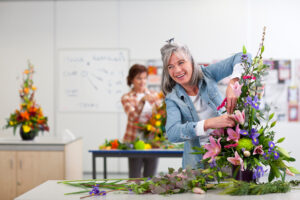 Woman designing flower arrangement in class