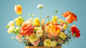 Orange flowers in basket on blue background