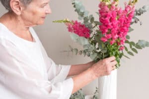 Woman arranging snapdragons with eucalyptus