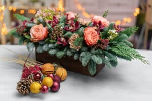 Holiday centerpiece with pine and peach roses
