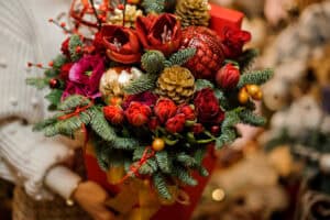 Person holding bouquet of winter florals and greens