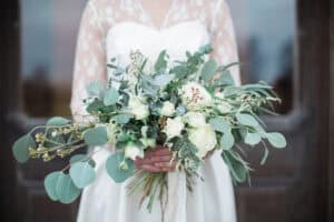 Bride carrying eucalyptus-heavy wedding bouquet