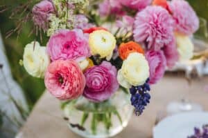 Vase of ranunculus and other blooms on table