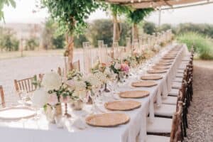 Long outdoor wedding table with settings and florals