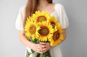 Woman holding sunflowers