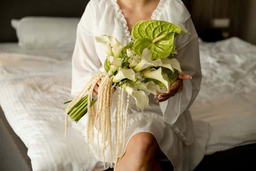 Bride holding bouquet with anthurium and calla lilies
